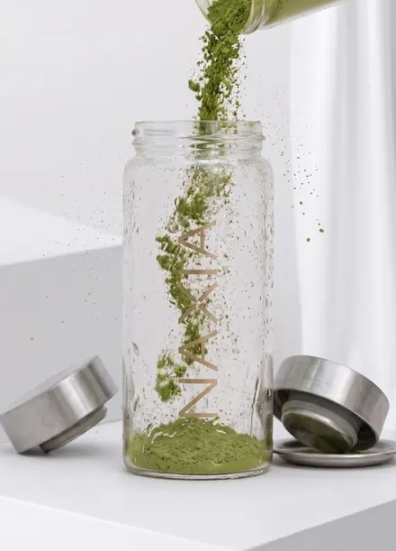 Vertiendo agua en un vaso con matcha NAXIA